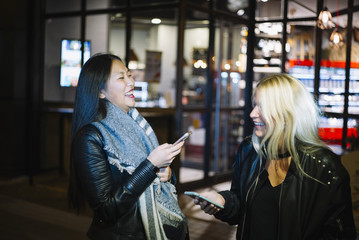 Blonde woman and asian woman go shopping.