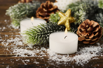 Christmas ornament with cone, candles and snow, selective focus