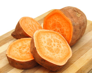 Sweet potatoes halves on wooden surface .