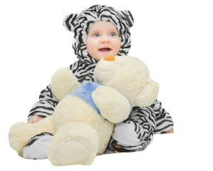 small child in a striped suit plays with Teddy bear