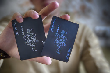 A man holds in his hands two playing cards 