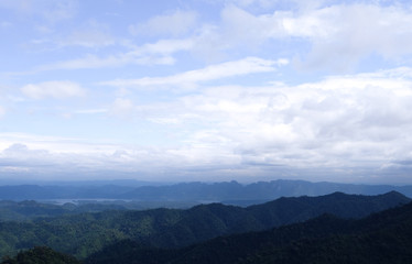 Beautiful mountain landscape, with mountain peaks covered with forest and a cloudy sky