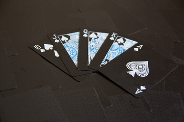 Royal Flush (oldest Straight flush) of spades poker cards combination against the background of...