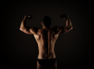 Fototapeta na wymiar Strong muscular man torso poses on black background