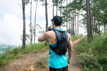 Athletic runner running on the tropical in the forest trail, dramatic tone