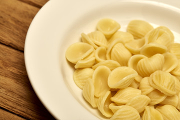 Pasta shell  in White Plate on wooden