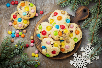 Children's cookies with colorful chocolate sweets in sugar glaze on brown concrete or stone background. Christmas card. Selective focus. Top view. Place for text.