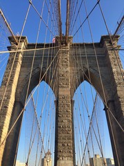 Naklejka premium Most Brooklyński i błękitne niebo w widoku z bliska