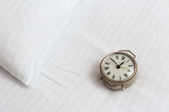 Vintage Alarm Clock On A Bed In A Hotel Room. Wake Up Call Concept