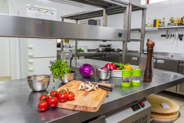 Various vegetables and kitchenware on a kitchen table in a restaurant