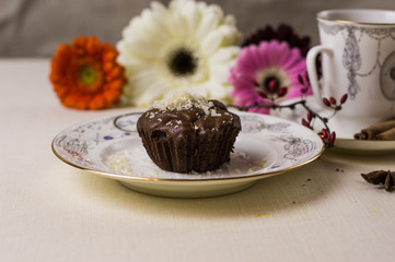 Chocolate fondant on a white plate with coffee and flowers