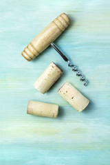 Fototapeta na wymiar Vintage corks and corkscrew on teal with copy space
