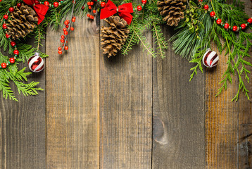 Christmas decorations and fir branches on wooden board background with copy space.