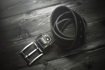 Leather belt buckle vintage wooden rough background. Retro style