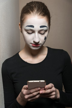 The girl in the image of mime with the phone