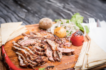 grilled meat on wooden plate marble table