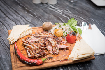 grilled meat on wooden plate marble table
