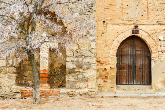 Puerta, cruz y árbol, fachada iglesia Otero de Sariegos. Reserva Natural Lagunas de Villafáfila, Zamora.
