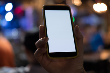 hand holding smartphone in pub. mobile phone with blank screen in restaurant