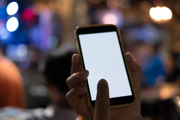 hand holding smartphone in pub. mobile phone with blank screen in restaurant