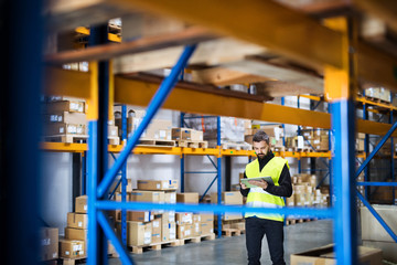 Male warehouse worker with tablet.