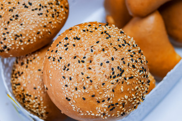 Fresh pastries, bread made from yeast dough, sprinkled with sesame seeds close-up