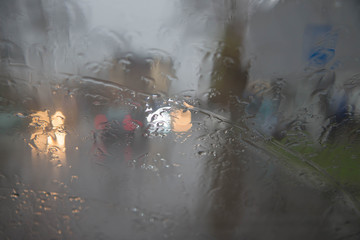 De focused image of rain falling on the road, looking out the window