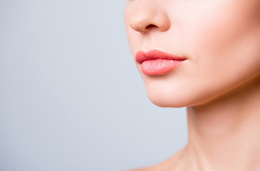 Cropped close up photo of beautiful woman's lips with shape correction, isolated on grey background, copyspace
