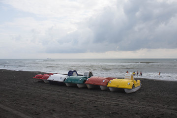 Colorful of pedal boat parked on the beach,overcast, clouds, waves