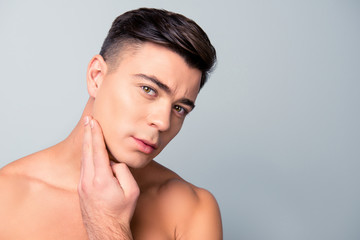 Close up portrait of satisfied confident handsome guy touching with shaved flawless clean soft skin...