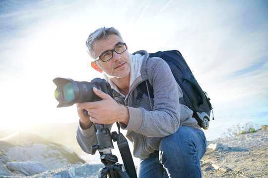 Portrait of photographer taking pictures in natural landscape