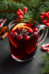 Christmas Mulled Wine with Orange and Cranberries. Holiday Concept Decorated with Fir Branches and Spices.Selective focus.