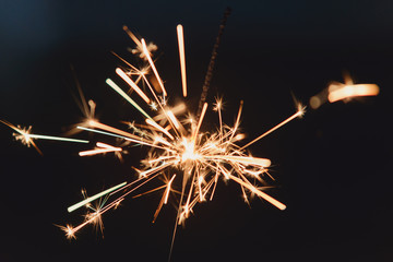 Fototapeta premium Sparkler with night background - bright festive Christmas or New Year’s Eve 