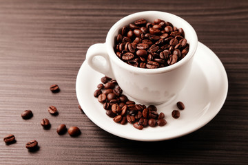 Coffee beans in a cup/ Coffee beans in a cup, standing on a wooden table