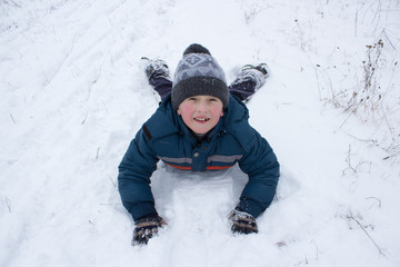 Fototapeta na wymiar boy lying on snow