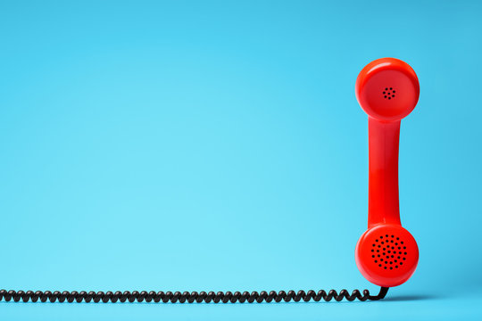 Red telephone in retro style on blue background.