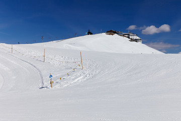 View to number 8 beginners blue ski slope at SCHMITTENHOHEBAHN 2000 meters peak with Elisabethkapelle on the top at Zell Am See Austria Alps mountain Schmitten resort
