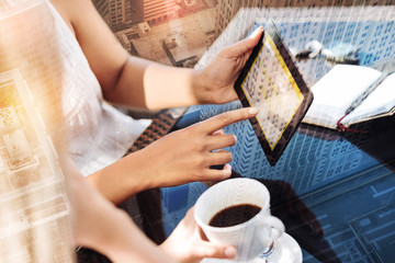 Coffee and talk. Tender female hands showing photo when coffee standing on the table