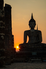 Silhouette of big buddha statue inside ruin temple at Sukhothai Historical Park