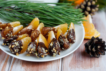 Mandarin in chocolate glaze and nuts on the table