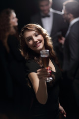 Plakat beautiful young woman raising his glass in a casino