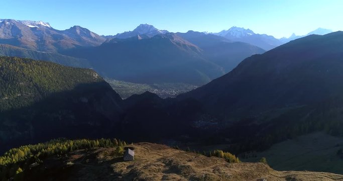 Mountain landscape, Cinema 4k aerial rising view over blatten alpine town, in a valley on a sunny autumn evening, on bealp, in wallis, of the alps in Switzerland
