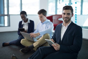 Executives using laptop and digital tablet
