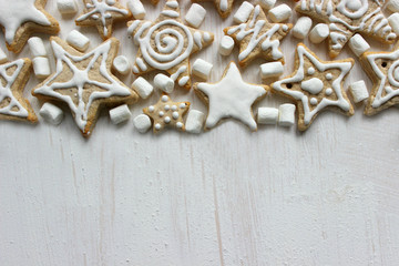 Christmas cookies with icing on white wooden vintage background. Gingerbread stars, abstract background, food