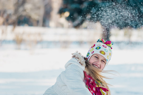 A girl plays snowballs