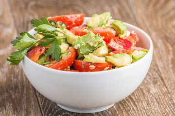 Avakoda salad with cherry tomatoes, lemon, cilantro leaves and pepper