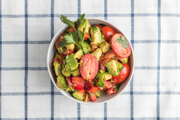 Avakoda salad with cherry tomatoes, lemon, cilantro leaves and pepper