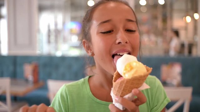 Cute Girl brunette eats Ice cream Cone, licks it with Tongue
