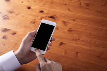 male hands using  whit smart phone  on wooden table