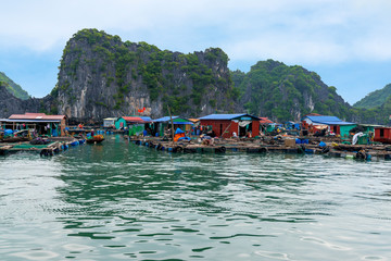 Fototapeta na wymiar Floating fishing village and rock island in Lan Ha Bay destination beautiful sea and the beach in Vietnam, Southeast Asia. UNESCO World Heritage Site.
